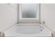 Close up on bathtub featuring tile surround and a window at 55 Prospectus Ln, Franklinton, NC 27525