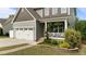 Stylish home with a two-car garage, welcoming front porch with ferns, and beautiful landscaping at 55 Prospectus Ln, Franklinton, NC 27525
