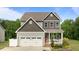 Charming two-story home with a front porch, two-car garage, and beautifully landscaped yard at 55 Prospectus Ln, Franklinton, NC 27525
