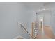 Upstairs hallway with wood floors and natural wood and black metal railing at 55 Prospectus Ln, Franklinton, NC 27525