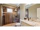Bathroom featuring a glass shower with decorative brown tiles, granite vanity, and modern fixtures at 603 Hawks Ridge Ct, Apex, NC 27539