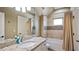 Bright bathroom featuring a large mirror, granite vanity top, and tub with shower at 603 Hawks Ridge Ct, Apex, NC 27539