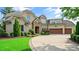 Stunning brick home featuring a stone entryway, manicured landscaping, and a spacious driveway leading to a three-car garage at 603 Hawks Ridge Ct, Apex, NC 27539