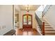 Elegant home foyer with a wooden front door, staircase with iron railings, hardwood floors, and a stylish chandelier at 603 Hawks Ridge Ct, Apex, NC 27539