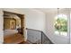 Second floor hallway with view into game room, hardwood floors, and a chandelier at 603 Hawks Ridge Ct, Apex, NC 27539