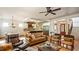Bright and airy living room with hardwood floors, tufted leather sofas, and open kitchen access with counter seating at 603 Hawks Ridge Ct, Apex, NC 27539