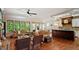 Spacious living area featuring hardwood floors, large windows, leather sofas, and an open concept layout with kitchen at 603 Hawks Ridge Ct, Apex, NC 27539