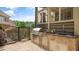 Covered outdoor kitchen area with a built-in grill, stone countertops, and sink at 603 Hawks Ridge Ct, Apex, NC 27539