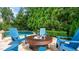 Relaxing pool area featuring blue chairs and a fire pit, surrounded by lush greenery at 603 Hawks Ridge Ct, Apex, NC 27539