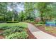 Lush park setting with walking path, wooden statue, and mature trees offering a peaceful community space at 603 Kildaire Farm Road Rd, Cary, NC 27511