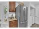 Close up of the kitchen with stainless steel refrigerator, granite countertops, and access to the laundry room at 608 Cross Timbers Dr, Durham, NC 27713