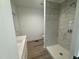 Bathroom with walk-in shower with marble tile, white cabinets, laminate flooring, and toilet at 612 Dunbar St, Durham, NC 27701
