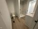 Bathroom with white cabinets, walk-in shower with marble tile, laminate flooring, and toilet at 612 Dunbar St, Durham, NC 27701
