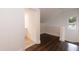 Hallway with dark laminate flooring, light gray paint, and view of secondary room at 612 Dunbar St, Durham, NC 27701