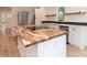 Kitchen featuring wood island, stainless steel appliances, floating shelves and eat-in bar at 612 Dunbar St, Durham, NC 27701