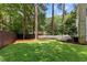 Large, grassy backyard with a brown fence and a line of tall trees for privacy at 6709 Sunhaven Pl, Raleigh, NC 27615