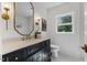 Charming bathroom with black vanity, gold accents, marble countertop, and a window view at 6709 Sunhaven Pl, Raleigh, NC 27615