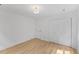 Bright bedroom with wood floors features a closet with double doors and an entry door at 6709 Sunhaven Pl, Raleigh, NC 27615