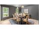 Sunlit dining room with a wooden table, stylish chairs, and modern lighting fixtures at 6709 Sunhaven Pl, Raleigh, NC 27615