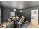Elegant dining room with dark gray walls, wood table, unique lighting, and classic chairs at 6709 Sunhaven Pl, Raleigh, NC 27615