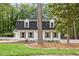 Charming two-story home with black roof, dormers, and a well-manicured lawn at 6709 Sunhaven Pl, Raleigh, NC 27615