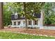 Charming two-story home with black roof, dormers, and a well-manicured lawn at 6709 Sunhaven Pl, Raleigh, NC 27615