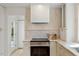 Bright kitchen featuring white cabinets, stainless steel oven, and marble countertops and backsplash at 6709 Sunhaven Pl, Raleigh, NC 27615