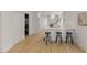 Bright and spacious kitchen featuring modern cabinets, a breakfast bar, and hardwood floors at 6709 Sunhaven Pl, Raleigh, NC 27615
