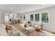 Open-concept living room with kitchen view, hardwood floors, and ample natural light at 6709 Sunhaven Pl, Raleigh, NC 27615