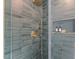 Close-up of the tiled shower with glass enclosure and brass fixtures at 6709 Sunhaven Pl, Raleigh, NC 27615
