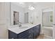 Bathroom with dual sinks, white countertops, blue vanity cabinets, a large mirror, and wood-look floors at 679 Jasmine Rd, Fuquay Varina, NC 27526