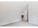 Bedroom with neutral carpet and trim, offering views through an open door to the kitchen at 679 Jasmine Rd, Fuquay Varina, NC 27526