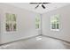 Bright bedroom with neutral carpet, white walls, large windows overlooking trees, and a ceiling fan at 679 Jasmine Rd, Fuquay Varina, NC 27526