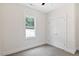 Bedroom with neutral carpet, white walls, large windows overlooking trees, and a double closet at 679 Jasmine Rd, Fuquay Varina, NC 27526