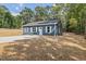 Quaint blue one-story home with a concrete driveway and lush green surroundings at 679 Jasmine Rd, Fuquay Varina, NC 27526