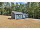 Cozy blue home in wooded setting with white shutters and a well-manicured lawn at 679 Jasmine Rd, Fuquay Varina, NC 27526