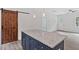 Close-up of kitchen island with gray countertop and blue cabinetry, complemented by a rustic sliding barn door at 679 Jasmine Rd, Fuquay Varina, NC 27526