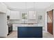 Modern kitchen with white cabinets, granite countertops, stainless steel appliances, and a navy-blue island at 679 Jasmine Rd, Fuquay Varina, NC 27526