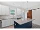 Stylish kitchen featuring a granite island, white cabinets, modern appliances, and a barn door at 679 Jasmine Rd, Fuquay Varina, NC 27526