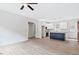 Open-concept living space with hardwood floors, white walls, ceiling fan, and kitchen island at 679 Jasmine Rd, Fuquay Varina, NC 27526