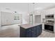 Open-concept living space with modern kitchen featuring a central island and stainless-steel appliances at 679 Jasmine Rd, Fuquay Varina, NC 27526