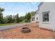 Brick patio featuring a fire pit and a view of the white brick home and lush trees at 70 S Patterson St, Coats, NC 27521
