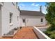 Brick patio of white brick home with charcoal roof under blue sky and landscaping at 70 S Patterson St, Coats, NC 27521