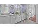 Bright bathroom featuring double sinks, white cabinetry, quartz countertops, and modern fixtures at 70 S Patterson St, Coats, NC 27521