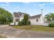 The exterior displays a beautiful white home with landscaped garden and mature trees at 70 S Patterson St, Coats, NC 27521