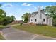 Exterior view of a white brick home with driveway, outbuilding, and lush trees at 70 S Patterson St, Coats, NC 27521