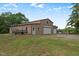 Image shows the garage with two roll-up doors and an equipment trailer at 70 S Patterson St, Coats, NC 27521