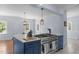 Island with range and oven, pendant lights, and open to dining area at 70 S Patterson St, Coats, NC 27521