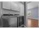 Modern laundry room with stainless steel appliances and upper cabinets at 70 S Patterson St, Coats, NC 27521