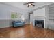 View of living room featuring hardwood floors, fireplace, large window and a comfortable couch at 70 S Patterson St, Coats, NC 27521